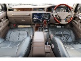 黒のレザー調のシートカバーに純正ウッドステアリングとウッドコ...